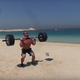 Dmitry Klokov trains on the beach in Duba. Image via Youtube